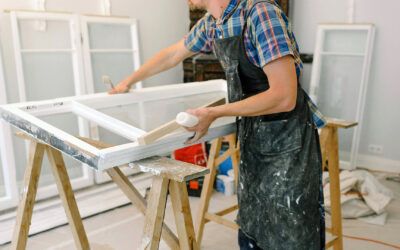 Handyman applying finishing touches to a window frame in a renovation setting, highlighting quality workmanship and attention to detail.